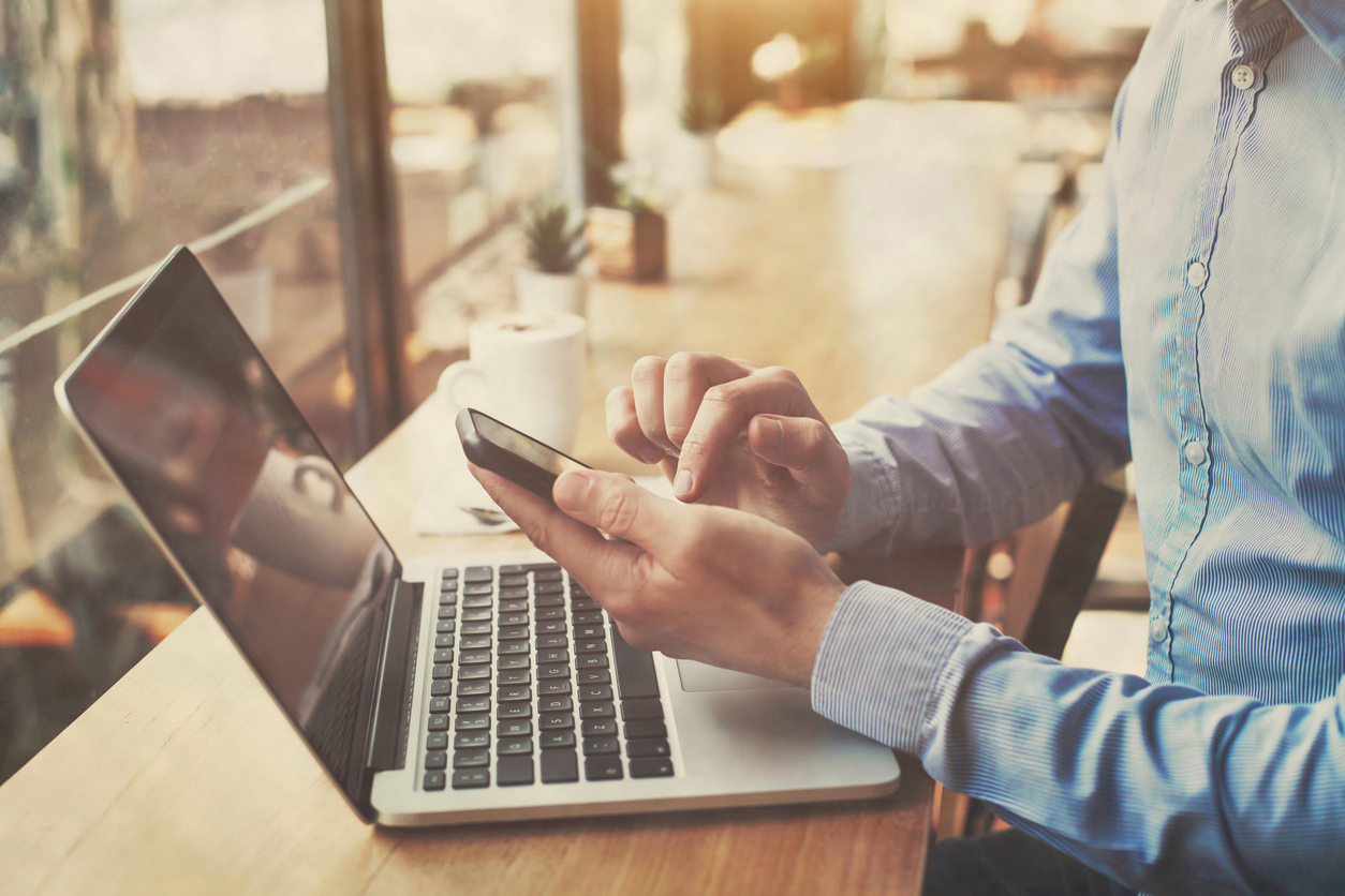 Man using phone and computer