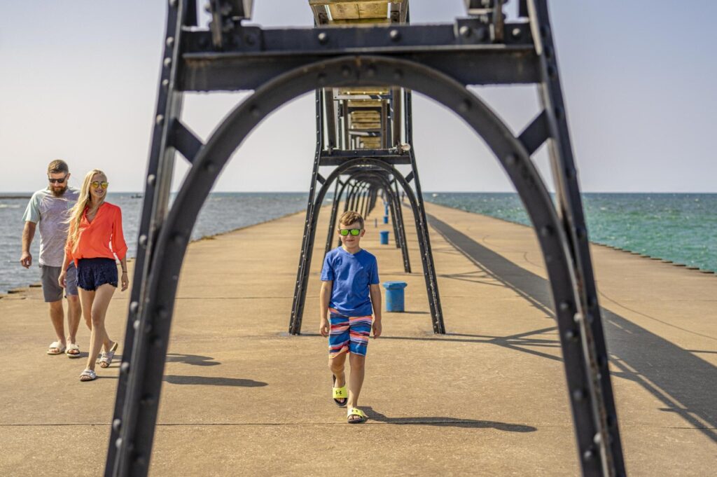 little boy walking under the lighthouse pier manistee michigan